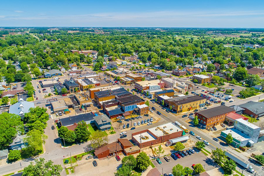 Contact - Aerial View of Small Town in Indiana with Trees, Communities and Farms in the Distance on a Bright Sunny Day